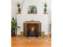 Close-up of a charming fireplace with decorative tile surround, wooden mantel shelves, and a protective metal screen at 1055 S Clayton Way, Denver, CO 80209