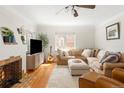 Bright living room with hardwood floors, comfortable seating, a cozy fireplace, and lots of natural light at 1055 S Clayton Way, Denver, CO 80209