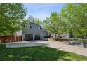 Two-story gray home featuring a well-maintained lawn and an attached three car garage at 2865 Newland St, Wheat Ridge, CO 80214