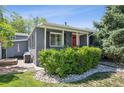 Attractive home with a red front door, mature landscaping, and a brick patio at 2865 Newland St, Wheat Ridge, CO 80214