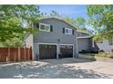 Charming two-story home with black shuttered windows, two-car garage, and a wooden fence at 2865 Newland St, Wheat Ridge, CO 80214
