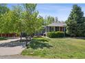 Well-maintained home with mature trees, a green lawn, and a walkway leading to the front door at 2865 Newland St, Wheat Ridge, CO 80214