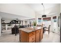 Open-concept kitchen with an island, granite countertops, and view of the adjacent living and dining areas, creating a connected space at 15776 E 107Th Way, Commerce City, CO 80022