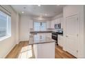 Island kitchen with granite countertops and light wood flooring at 23881 E 40Th Ave, Aurora, CO 80019