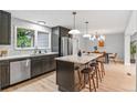 Modern kitchen with stainless steel appliances, a large center island with seating, and stylish light fixtures at 4682 Chatham St, Boulder, CO 80301