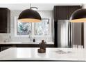 Bright kitchen with a window above the sink, white quartz countertops, stainless appliances, and modern pendant lighting at 4682 Chatham St, Boulder, CO 80301