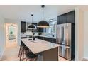Modern kitchen features stainless steel appliances, black cabinets, and a marble island with bar stool seating at 4682 Chatham St, Boulder, CO 80301
