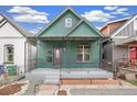 Green home featuring an inviting front porch with decorative ironwork and gray steps at 3306 N Gilpin St, Denver, CO 80205