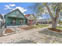 Street view of a quaint green home with rock and mulch landscaping at 3306 N Gilpin St, Denver, CO 80205