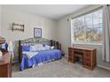 Comfortable bedroom with neutral carpet, natural light, and a classic wood desk at 10153 Pagosa St, Commerce City, CO 80022