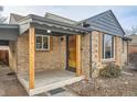 Inviting front porch featuring new tile, gray trim and wood supports and shutters at 3045 Kearny Street, Denver, CO 80207