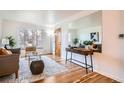 Cozy living room with hardwood floors, large window, and a decorative mirror at 3045 Kearny Street, Denver, CO 80207