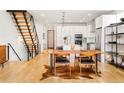 Modern kitchen with white cabinetry, stainless steel appliances, a large island, and a stylish wooden dining table at 3957 Utica St, Denver, CO 80212
