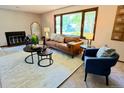 Bright living room with a decorative fireplace, large window, and comfortable seating arrangement at 53 Douglas S Dr, Broomfield, CO 80020