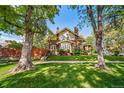 2-story brick home with a large front yard and mature trees at 2203 Bellaire St, Denver, CO 80207