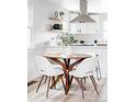 Cozy dining area featuring a round table with four chairs, with a view of the modern kitchen at 1405 Eaton St, Lakewood, CO 80214