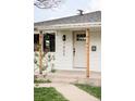 Charming front porch with updated door and hardware and a view of the front lawn at 1405 Eaton St, Lakewood, CO 80214