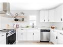 Bright kitchen featuring white cabinets, stainless steel appliances, floating shelves, and modern countertops at 1405 Eaton St, Lakewood, CO 80214