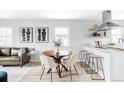 Open living area featuring a dining table with chairs, a modern kitchen, and a comfortable couch at 1405 Eaton St, Lakewood, CO 80214
