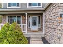 Charming front porch features stone accents, white trim, and a 