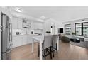 Contemporary kitchen featuring sleek white cabinetry, stainless steel appliances, and a breakfast bar at 1750 Wewatta St # 1301, Denver, CO 80202