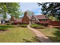 Charming brick home with a well-manicured lawn and a stone pathway leading to the front door at 2500 Locust St, Denver, CO 80207