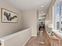 Bright hallway with hardwood floors, neutral walls, and access to other rooms at 3280 Young Heart Way, Castle Rock, CO 80109