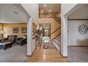 Inviting home entryway with wood floors, staircase, and open access to living room and other areas at 9251 Sand Hill Trl, Highlands Ranch, CO 80126