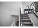 Modern staircase features gray carpeting, contrasting dark railings, and leads to the upper level at 441 Elbert Way, Denver, CO 80221