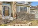 Inviting front entrance of a well-maintained home, featuring brick accents and mature landscaping at 14045 E Grand Ave, Aurora, CO 80015