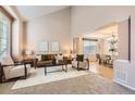 Bright and airy living room with high ceilings and a seamless transition to the dining area at 14045 E Grand Ave, Aurora, CO 80015