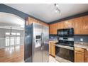 Functional kitchen with stainless steel appliances, wood cabinets, and a view of the second story at 1473 Red Cliff Way, Castle Rock, CO 80109