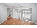 A living room features hardwood floors, a staircase, and white railings at 1473 Red Cliff Way, Castle Rock, CO 80109