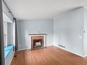 Cozy living room with a brick fireplace, wood floors, and a window seat offering natural light and comfort at 298 S Hoover Ave, Louisville, CO 80027