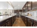 Modern kitchen with white quartz countertops, dark wood cabinets, and stainless steel appliances at 14278 Forest St, Thornton, CO 80602