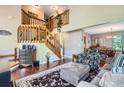Elegant foyer featuring a grand staircase, hardwood floors, and an open layout into the living and dining areas at 4203 E 126Th Ave, Thornton, CO 80241