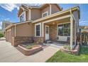 Inviting front porch with a cozy bench, brick accents, and a well-manicured garden bed at 4203 E 126Th Ave, Thornton, CO 80241