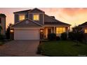 Charming two-story home with warm interior lights glowing at twilight at 5613 S Sicily Cir, Aurora, CO 80015