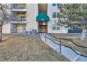 Inviting entrance to building #9 featuring a landscaped walkway with railings and well maintained common area at 12338 W Dorado Pl # 107, Littleton, CO 80127