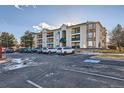 Spacious condo building featuring multiple balconies, complemented by a parking area and well-maintained surroundings at 12338 W Dorado Pl # 107, Littleton, CO 80127