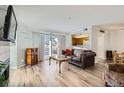 Inviting living room features wood floors, a sliding door to a balcony, and a passthrough to the kitchen at 12338 W Dorado Pl # 107, Littleton, CO 80127