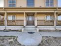 Close-up of the home's entry with a decorative front door and welcoming porch at 14855 Almstead St, Hudson, CO 80642