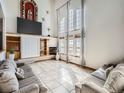 Bright living room with large windows, tile floors, and fireplace, offering a cozy space for relaxation and entertainment at 14855 Almstead St, Hudson, CO 80642
