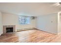 Bright and airy living room featuring hardwood floors, a fireplace, and a large window allowing for ample natural light at 336 N Grant St # 412, Denver, CO 80203
