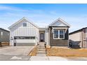 Charming home with gray siding, brick accents, and a two-car garage, enhanced by a red entry door at 6675 Fawn Path Ln, Castle Pines, CO 80108
