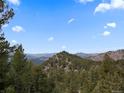Scenic mountain view with trees and partial blue skies at 3945 Douglas Mountain Dr, Golden, CO 80403