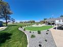 Landscaped backyard featuring a well-manicured lawn, gravel pathways, and a cozy seating area at 15945 Delta Ct, Brighton, CO 80603