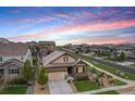 Aerial view of a house with a manicured lawn nestled in a neighborhood with sunset sky at 3480 Mount Powell Dr, Broomfield, CO 80023