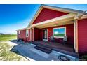 Inviting covered porch with seating, perfect for enjoying peaceful outdoor moments at 46122 County Road 53, Bennett, CO 80102