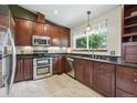 Modern kitchen with stainless steel appliances, granite countertops, and dark wood cabinetry at 3973 S Joplin Way, Aurora, CO 80013